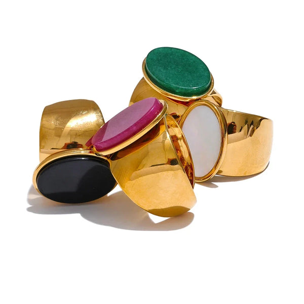 Gold rings with colorful gemstones on a white background.