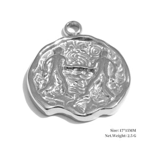 Silver pendant with intricate design on a white background