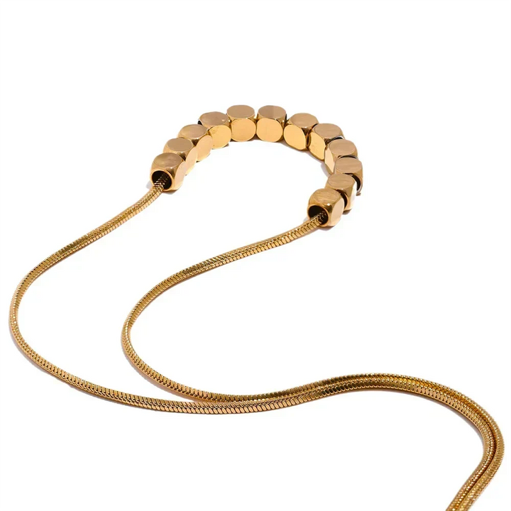 Gold beaded necklace on a white background
