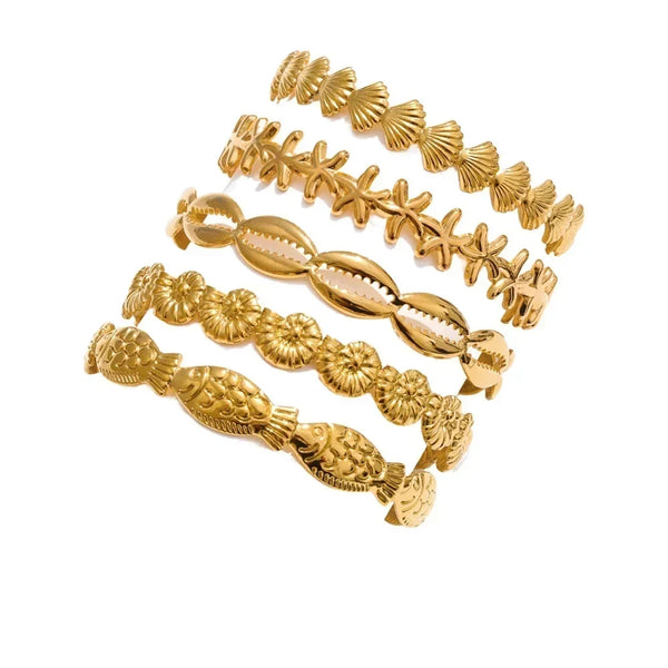 Set of gold bracelets with intricate designs on a white background