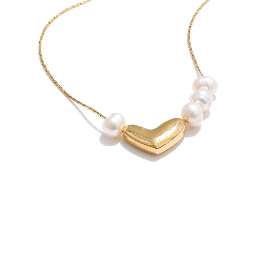 A heart-shaped gold pendant necklace accompanied by small natural pearls, presented on a chainز