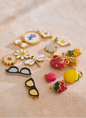 Collection of colorful jewelry charms on a beige surface