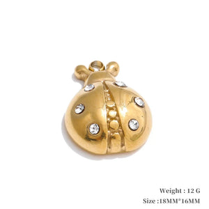 Gold ladybug pendant with embedded crystals on a white background