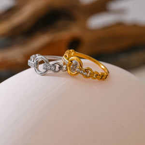 Two rings, one gold and one silver, on a neutral background