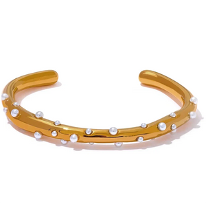 Gold bracelet with pearls on a white background