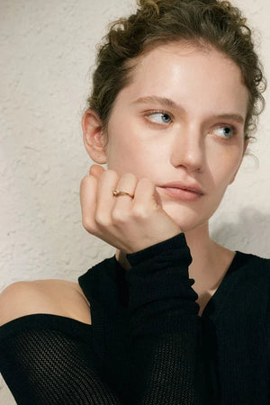 Woman wearing a black top with a textured beige background