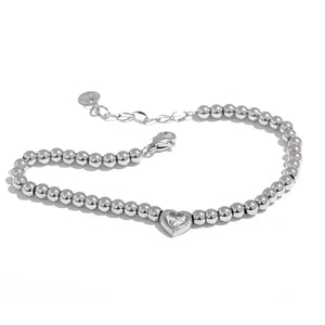 Steel beaded bracelet with heart-shaped crystal centerpiece on white background