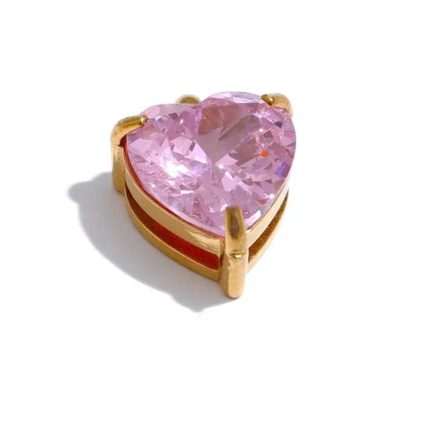 Heart-shaped pink gemstone in a gold setting on a white background