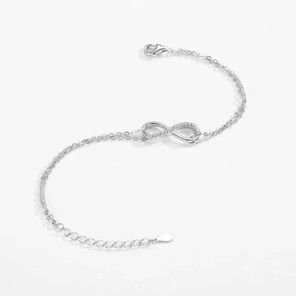 Sterling silver infinity symbol bracelet with delicate chain on white background