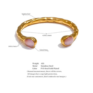 Gold bracelet with pink stones on a white background