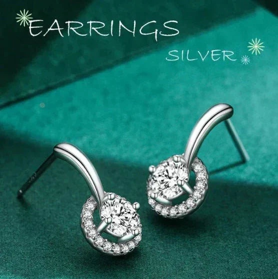 Silver earrings with gemstones on a teal background