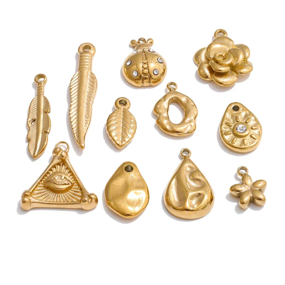 Collection of gold jewelry pendants on a white background.