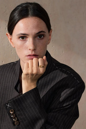 Woman wearing a pinstripe suit with a neutral background