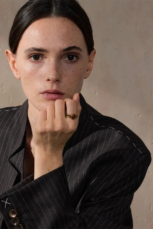 Woman wearing a pinstripe suit with a neutral background