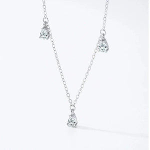 A delicate silver-toned chain necklace with three small teardrop-shaped clear gemstone pendants, displayed against a clean white background with a subtle shadow.