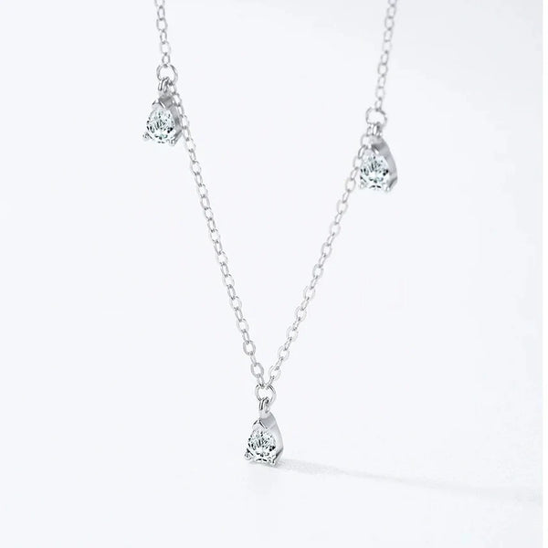 A delicate silver-toned chain necklace with three small teardrop-shaped clear gemstone pendants, displayed against a clean white background with a subtle shadow.