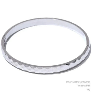 steel bangle with textured design on a white background