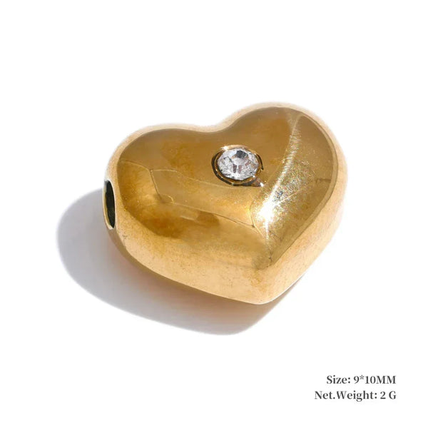 Gold heart-shaped pendant with a diamond on a white background