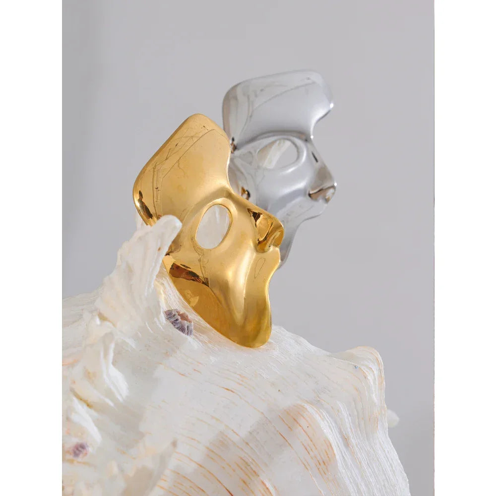 Two halves of a broken shell, one gold and one silver, on a white background.