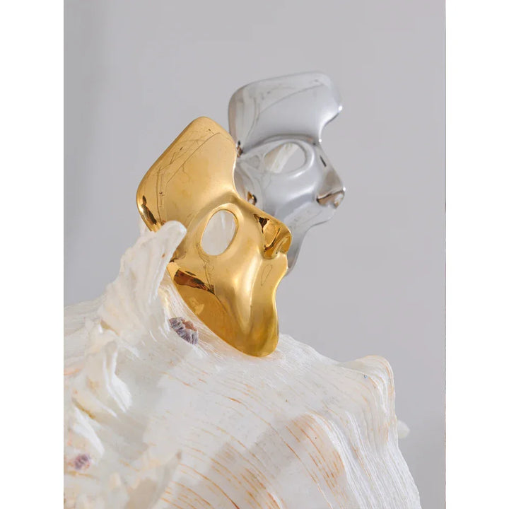 Two halves of a broken shell, one gold and one silver, on a white background.