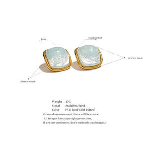 Gold and resin earrings with technical details on a white background