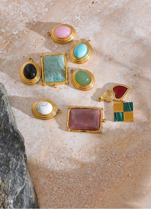 Collection of colorful gemstone earrings on a textured surface