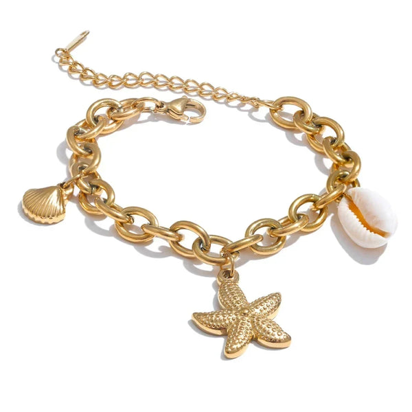Gold chain bracelet with starfish and shell charms on a white background.