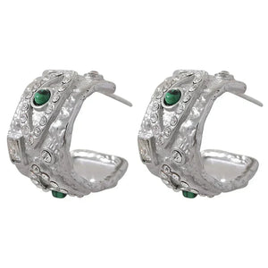 Pair of silver hoop earrings with green gemstones on a white background