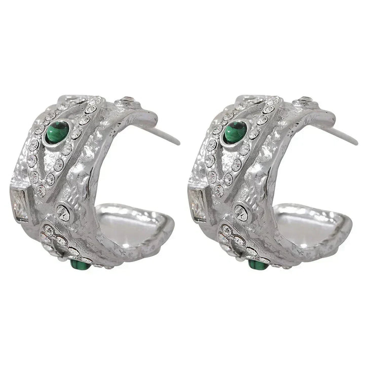 Pair of silver hoop earrings with green gemstones on a white background