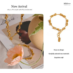 Gold jewelry set including necklace, bracelet, and ring on a magazine background with 'NEW++' branding.
