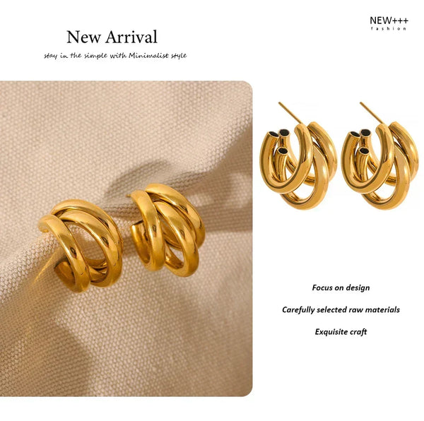 Gold hoop earrings on a beige fabric background with 'NEW++' branding.