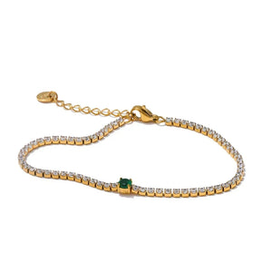 Gold bracelet with green gemstone on a white background