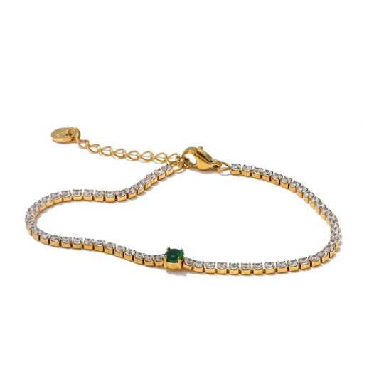 Gold bracelet with green gemstone on a white background