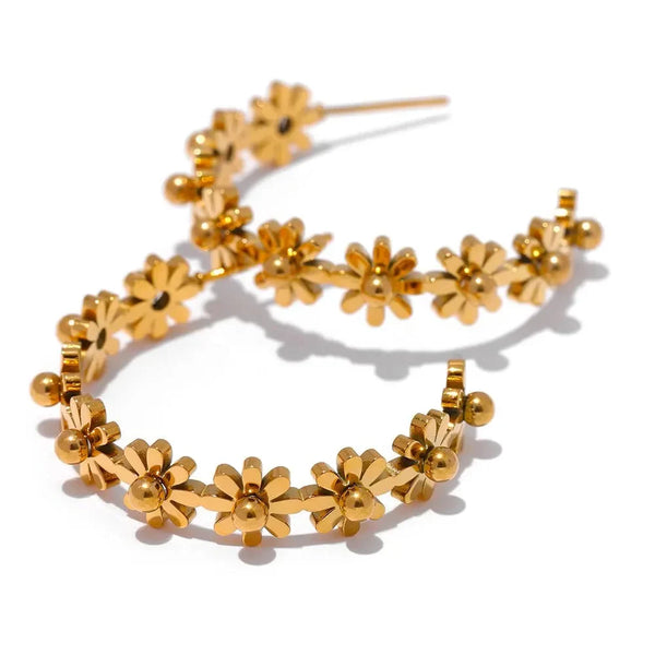 Gold floral hoop earrings on a white background