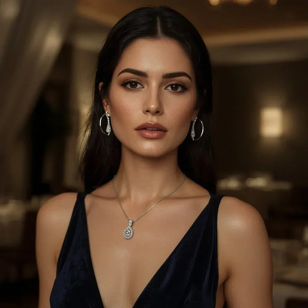 Woman wearing a black dress with a necklace and earrings in an indoor setting