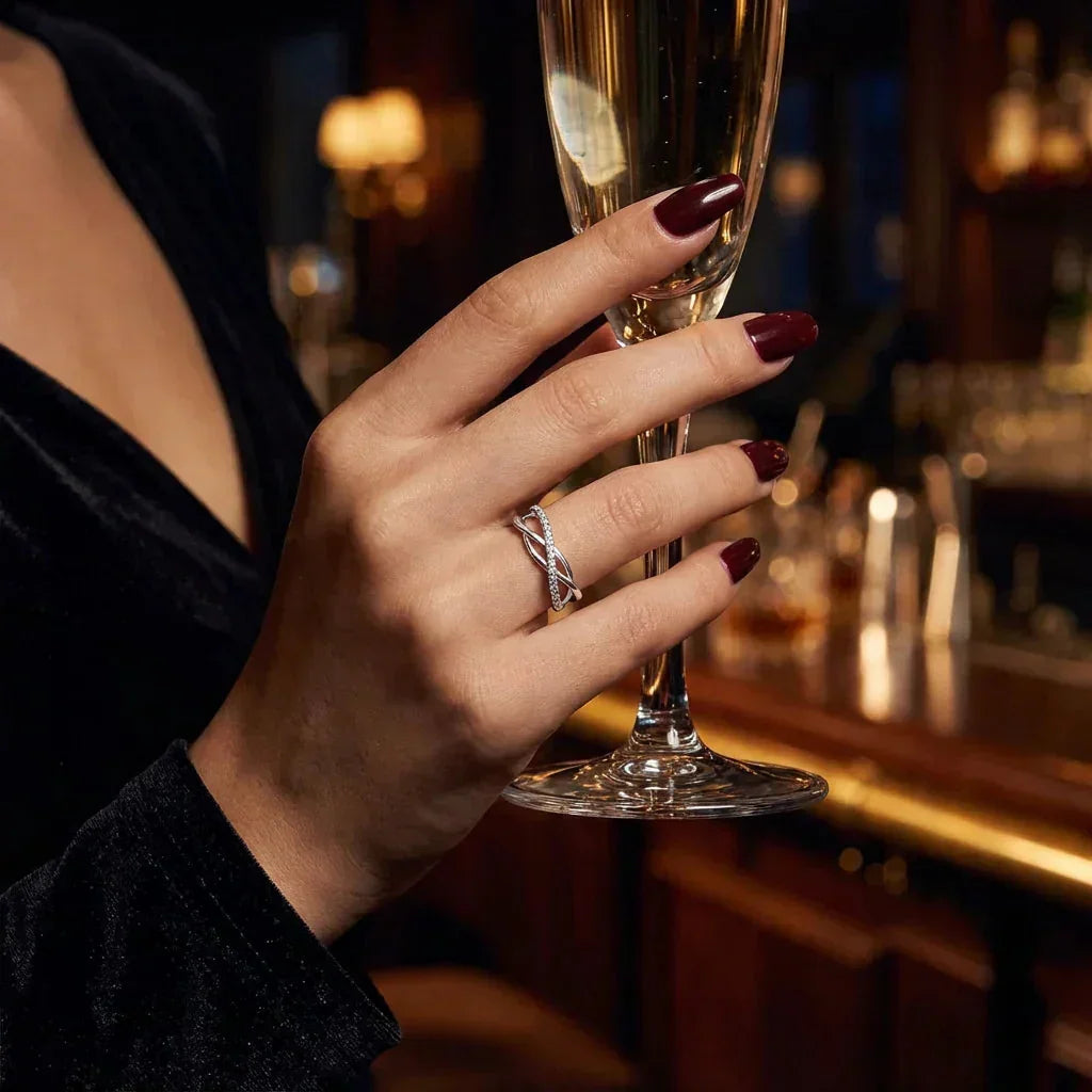 Hand holding a glass of champagne with a blurred bar background