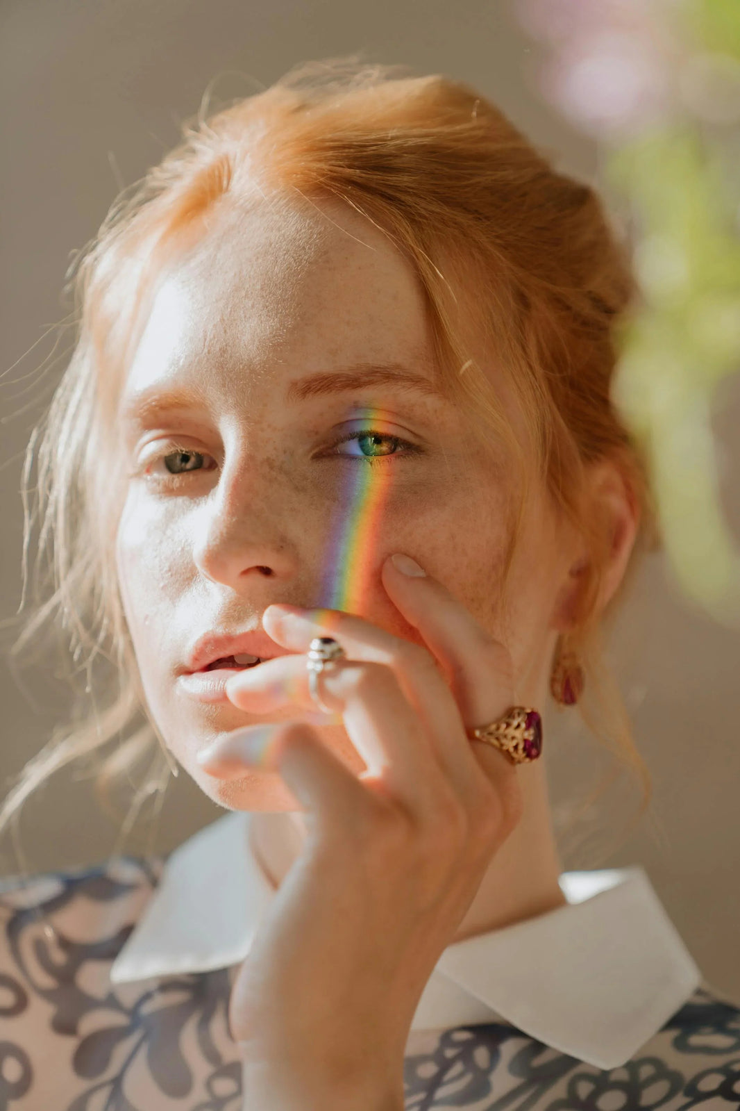 Person with a rainbow折射在脸上，背景柔和