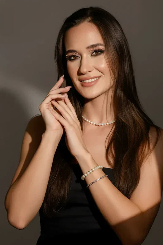 A model wearing a quality-crafted pearl choker and layered bracelet stack from the TM & Co. Jewels collection.