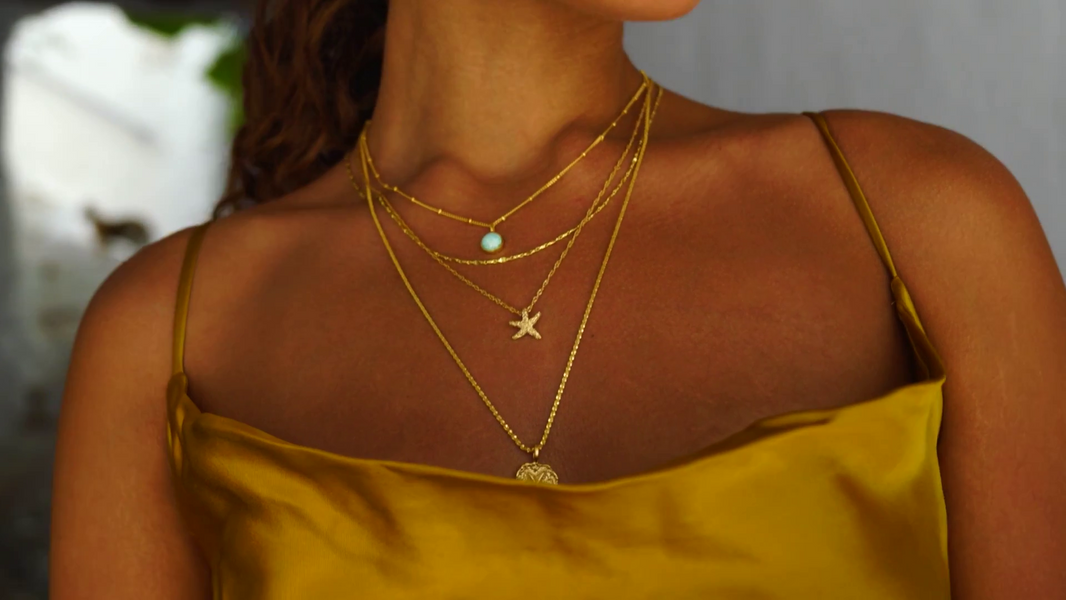 Woman wearing gold necklaces with a blurred background